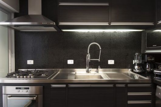 Cozinha preta com revestimento de tijolinho preto e branco