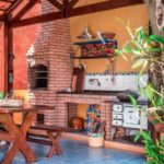 Área decorada com churrasqueira - Churrasqueira com tijolo à vista e ambiente com cores vibrantes