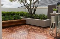 Deck de madeira amplo na varanda com belo jardim