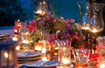 Decoração de Mesa de Jantar - Mesa de madeira para jantar a luz de velas e várias flores compondo o ambiente