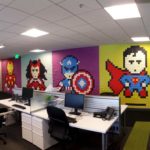 Escritório corporativo com parede decorada de super-heróis