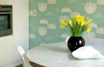 Cozinha com papel de parede verde com ilustrações