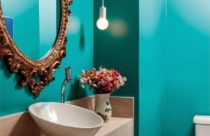 Lavabo pequeno com papel de parede na cor verde e espelho veneziano