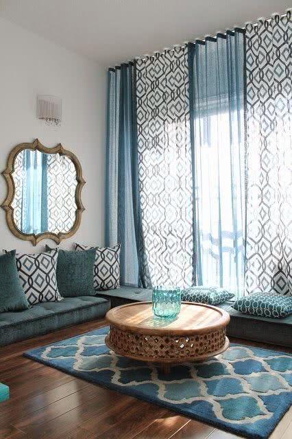 Cortina azul e estampada combinando com a sala de estar