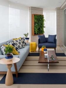 Tapete listrado para decoração de varanda com sofá e poltrona azul